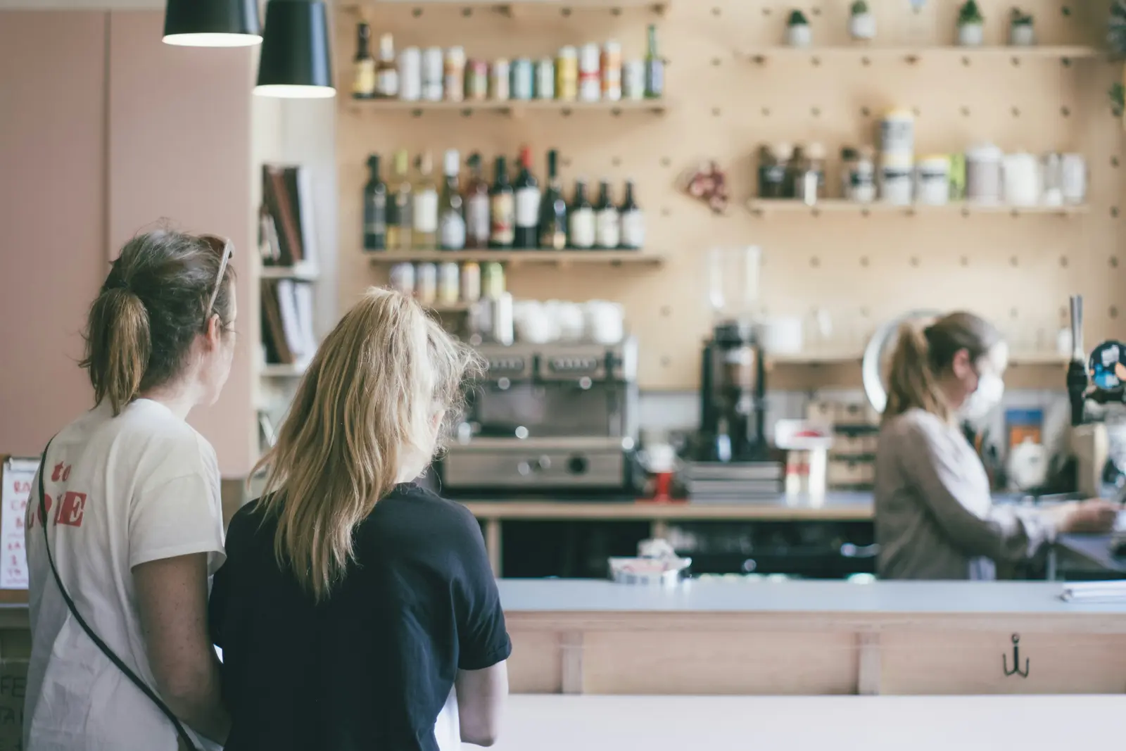 Equipo de una cafetería atendiendo detrás del mostrador.